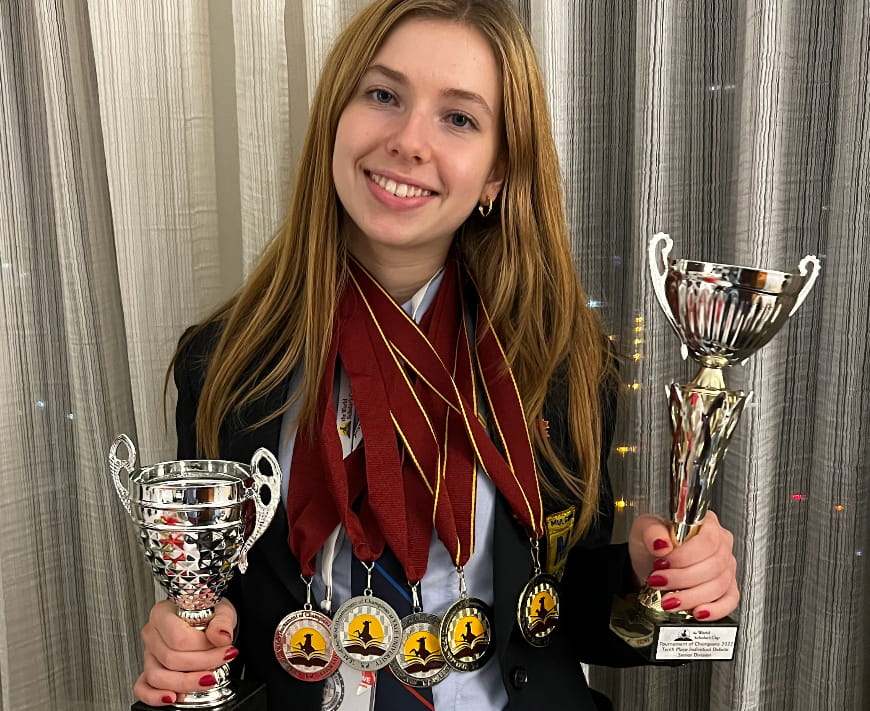Martina Revello holding lost of trophies after winning first in world scholars cup